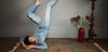 Model in denim clothing lying on a persian rug with legs against the wall