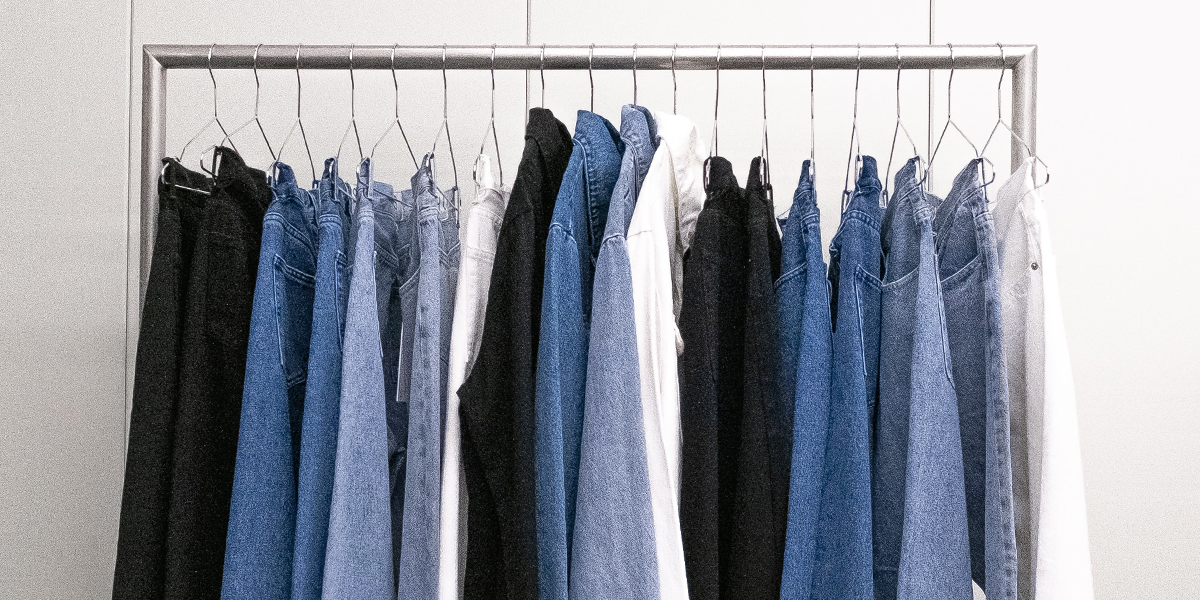 Photo of a rail of jeans/blue and neutral coloured clothing hanging up