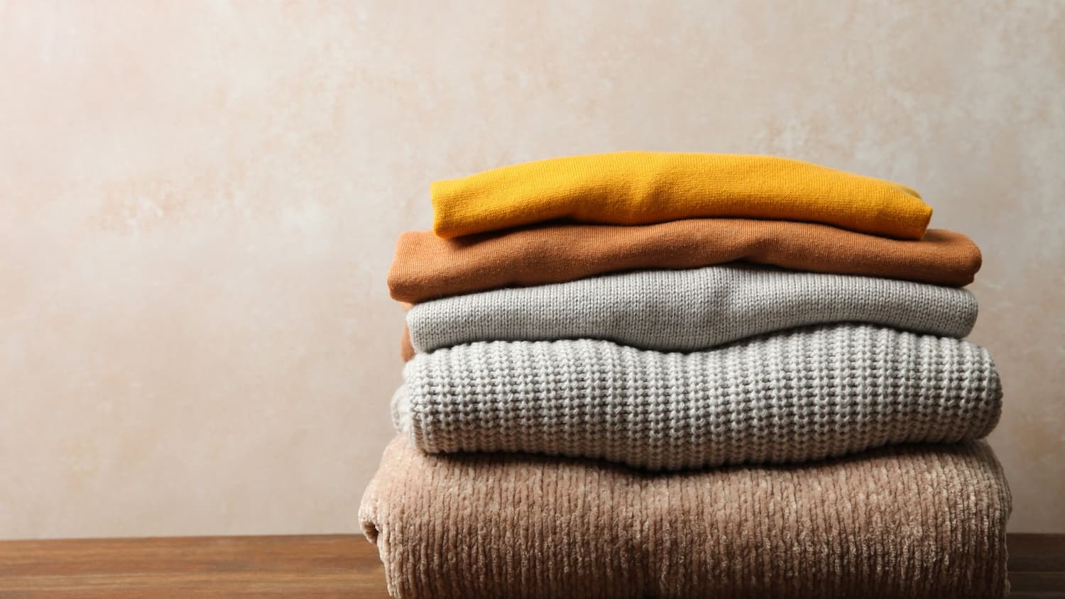 Pile of cashmere knitwear in autumnal colours 
