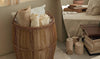 Wicker laundry basket filled with white and cream laundry