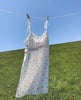 White strappy dress on a washing line with countryside background