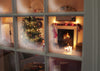 Christmas living room scene including a Christmas tree, lit fireplace and decorated mantle piece seen through a fogged up window