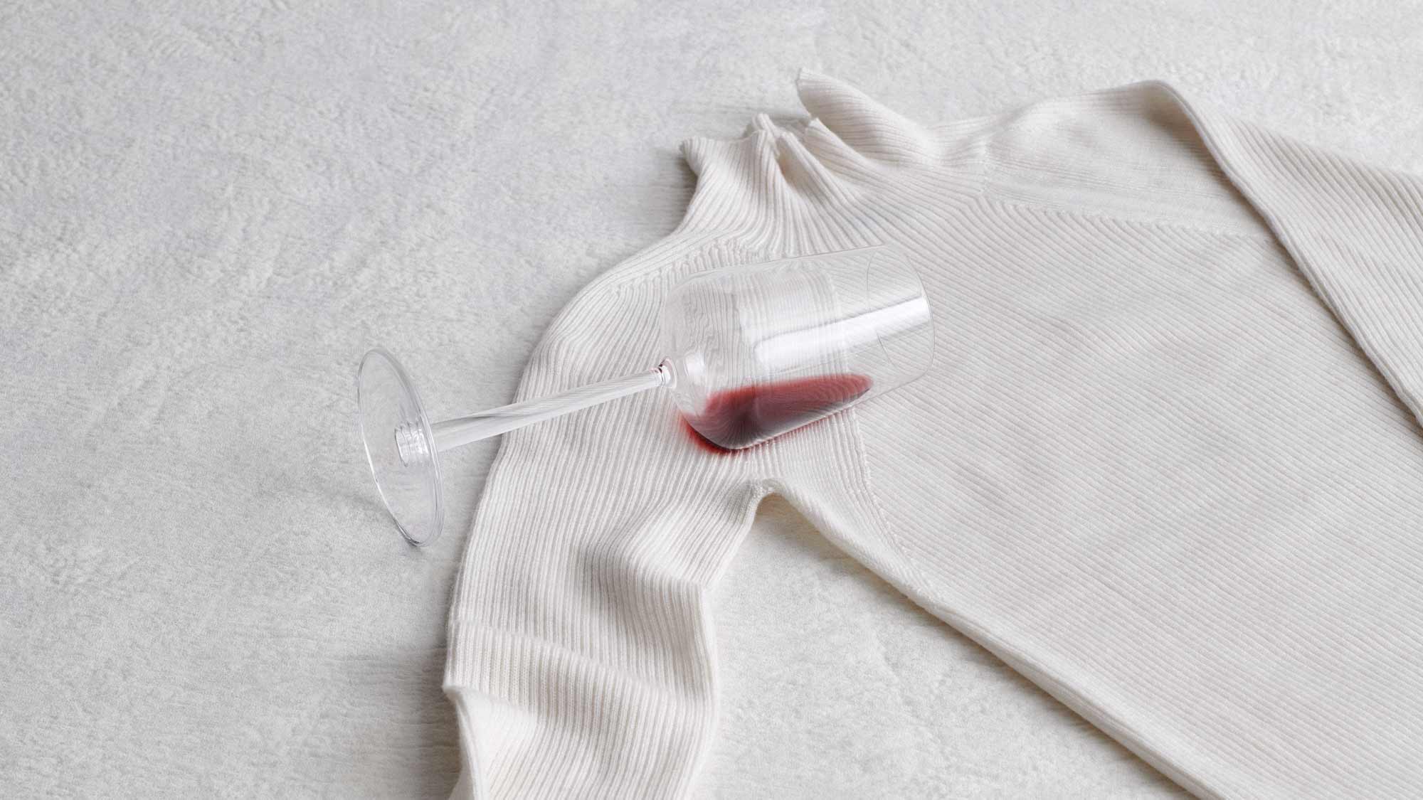 Glass of red wine lying on a cream jumper