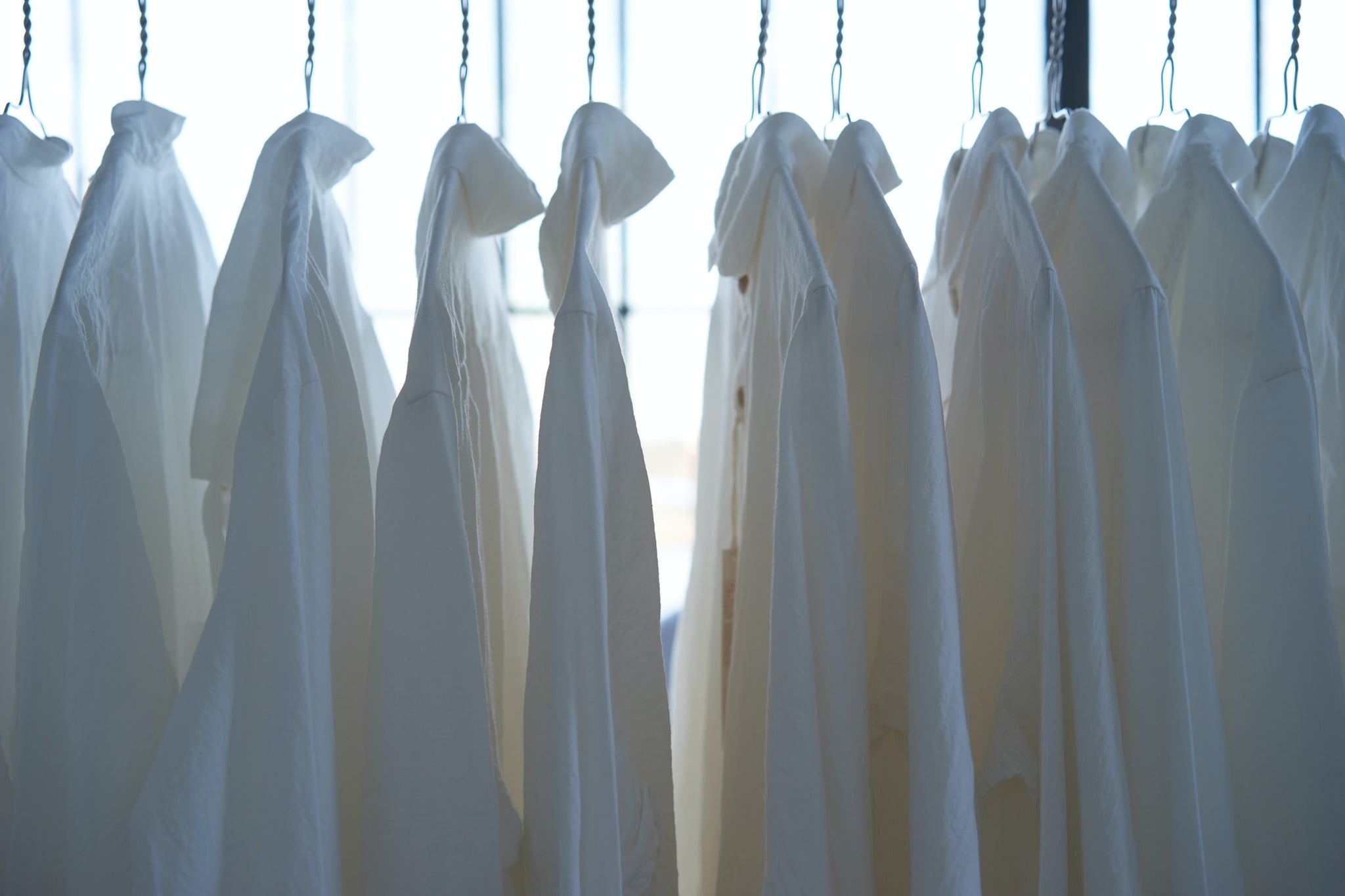 Photo of a rail of white shirts hanging up